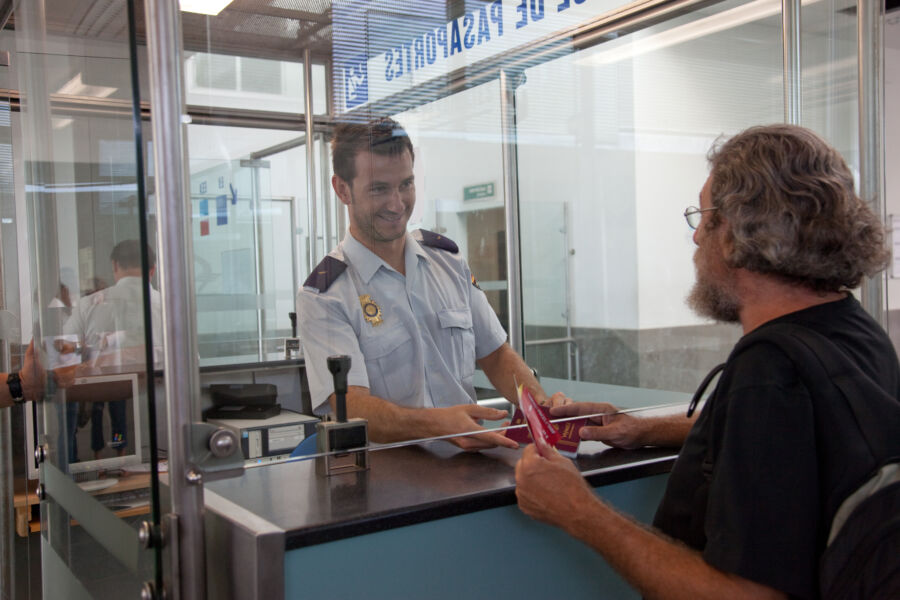 A man speaking with an immigration officer.