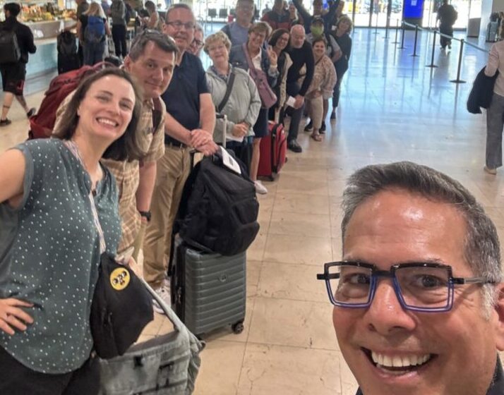 A happy group of travelers waiting for a train