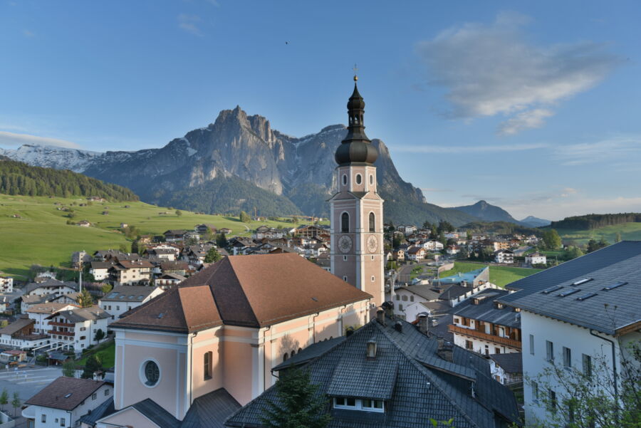 An Italian village set before a mountainous backdrop.