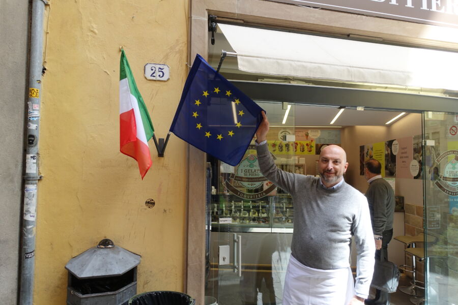 A gelateria worker in Italy proudly holds an EU flag.