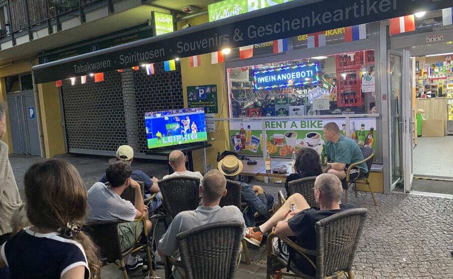 People crowding around a TV showing a soccer game.