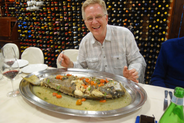 Rick Steves with big fish on plate