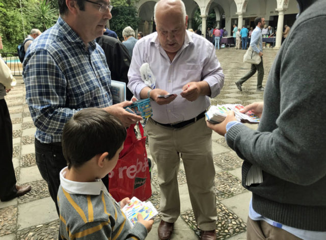 young boy and older men staring at cards in their hands